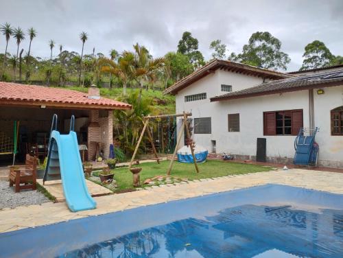 une maison avec une piscine et une aire de jeux dans l'établissement Recanto Kamei-Piscina climatizada, à São Roque