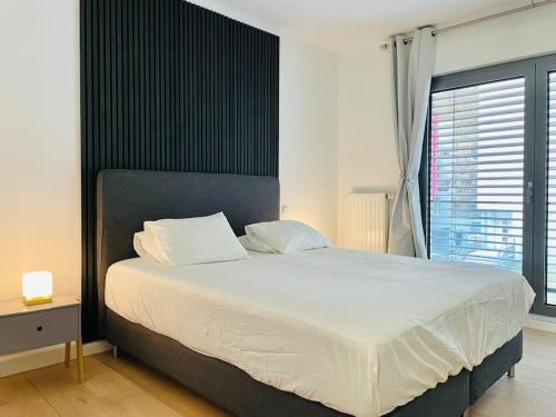 a bedroom with a large white bed and a window at Brand New Large Family Flat in Center- Parking -N1 in Luxembourg