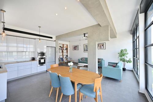 uma cozinha e sala de jantar com uma mesa de madeira e cadeiras em Luna Moona by HolyGuest em Tel Aviv