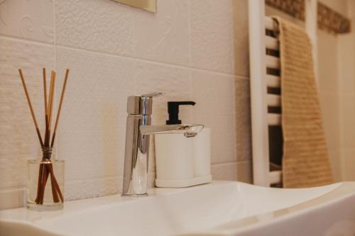 a bathroom sink with a faucet and a candle at Apartment Latte in Budapest