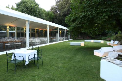 a group of tables and chairs in a grass field at Hotel Quinta das Lagrimas - Small Luxury Hotels in Coimbra