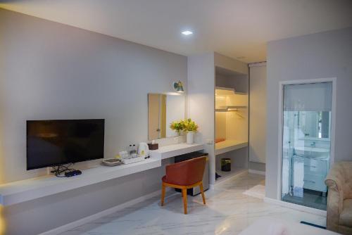 JB Grand Resort في ناخون سي ثامارات: غرفة معيشة مع تلفزيون بشاشة مسطحة على جدار