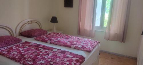 プラヤ・デル・イングレスにあるSun Club Bungalowsのベッドルーム1室(ピンクのシーツが備わるベッド2台、窓付)