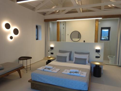 ein Schlafzimmer mit einem Bett mit 2 Tischen und einem Spiegel in der Unterkunft Niki Luxury Apartments Niki Suites Petra in Petra