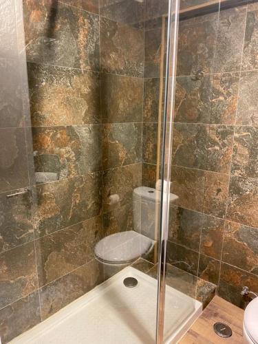 a bathroom with a toilet and a glass shower at A Casa do Chapéu de Palha in Setúbal