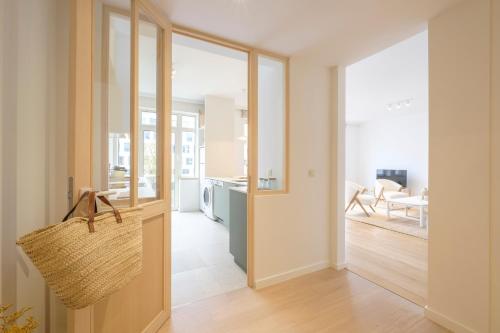 um corredor com uma porta que leva a uma cozinha e a uma sala de estar em Lumineux Appartement 2 chambres entre le Châtelain et l'Avenue Louise em Bruxelas