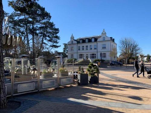 a large white building with people walking in front of it at Ferienwohnung Möwennest in Timmendorfer Strand