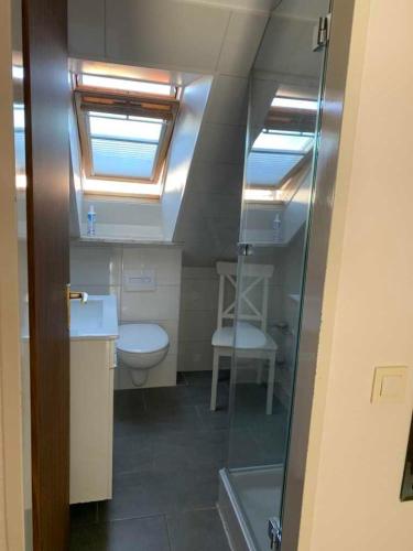 a bathroom with a toilet and a sink and a window at Ferienwohnung Möwennest in Timmendorfer Strand
