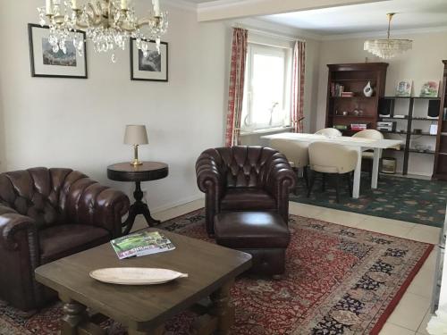 a living room with leather chairs and a table at Ferienwohnung Ostseewellen in Timmendorfer Strand