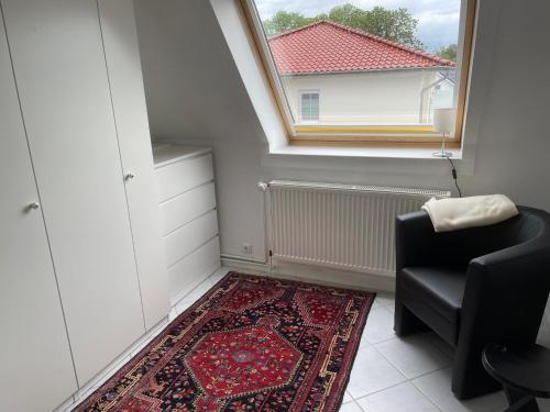 a room with a window and a chair and a rug at Ferienwohnung Ostseewellen in Timmendorfer Strand