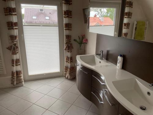 a bathroom with a sink and a large mirror at Ferienwohnung Ostseewellen in Timmendorfer Strand