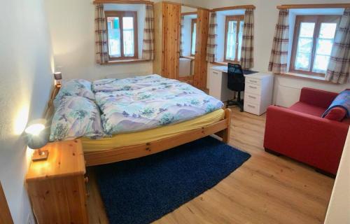 um quarto com uma cama e um sofá vermelho em Privatzimmer Fasser in Müstair- Zentrale Lage em Müstair