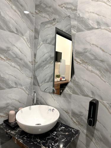 a bathroom with a white sink and a mirror at VÂN TRANG GARDEN HOTEL 2 in Vĩnh Long