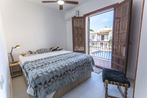 sypialnia z łóżkiem i dużym oknem w obiekcie Canovas Nerja - Nueva Nerja - Pueblo Andaluz 94 w mieście Nerja