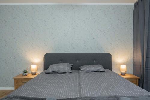 a bedroom with a large bed with two candles on tables at Loode lux with sauna in Tartu