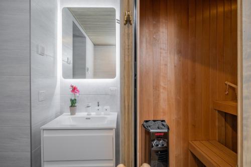 a bathroom with a white sink and a mirror at Loode lux with sauna in Tartu