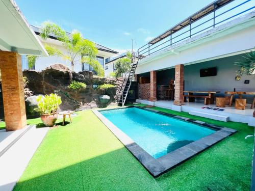 a swimming pool in the backyard of a house at Gangga Guest House in Canggu