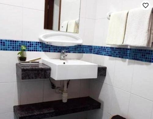 y baño con lavabo blanco y espejo. en Queens Rentals - Studio Apartments - Village Walkway - Masaki - Dar es Salaam, en Dar es Salaam