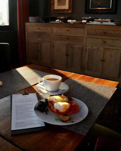 a plate of eggs and a cup of coffee on a table at The Principal Madrid, Small Luxury Hotels in Madrid