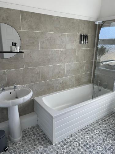 a bathroom with a white tub and a sink at STOP at Talbot Road! in Port Talbot