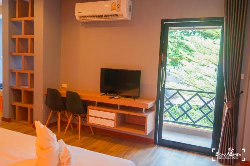 a room with a desk with a television and a window at Little Paradise Haad Rin Koh Phangan in Haad Rin
