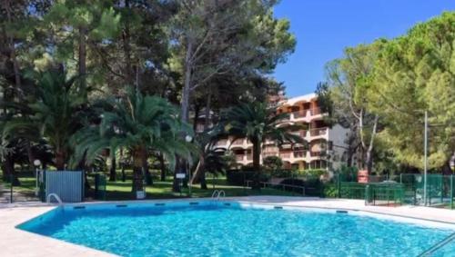 une grande piscine en face d'un bâtiment dans l'établissement Bel appartement terrasse au 4ème et dernier étage, à Mandelieu-la-Napoule