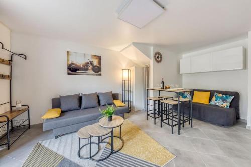 una sala de estar con un sofá y una mesa en Cocoon - Jardin - Boite à clé - Wi-Fi, en Baulne