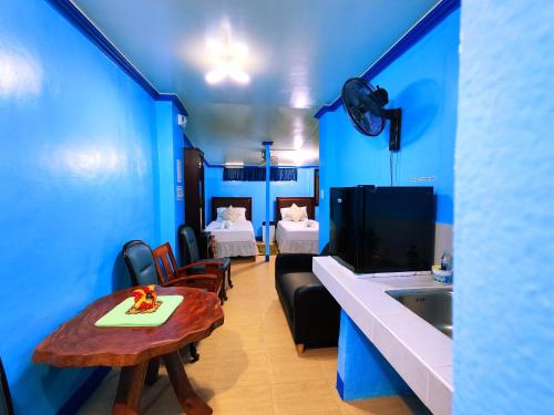 a room with blue walls and a table and a sink at Evan's Homestay in Basco