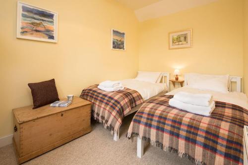 a room with two beds and a nightstand at The Heritage Cottage in Swinton