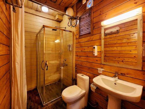 uma casa de banho com um WC, um chuveiro e um lavatório. em La Vie Woods- couples/families only em Calangute