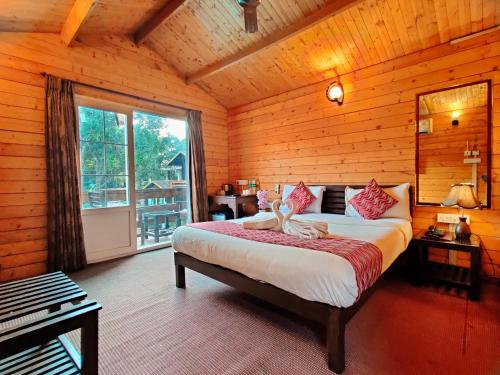 a bedroom with a bed and a large window at La Vie Woods- couples/families only in Calangute