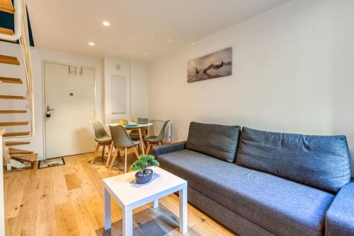 un salon avec un canapé bleu et une table dans l'établissement #14 Duplex Tonduti terrace 5min Old Town, à Nice