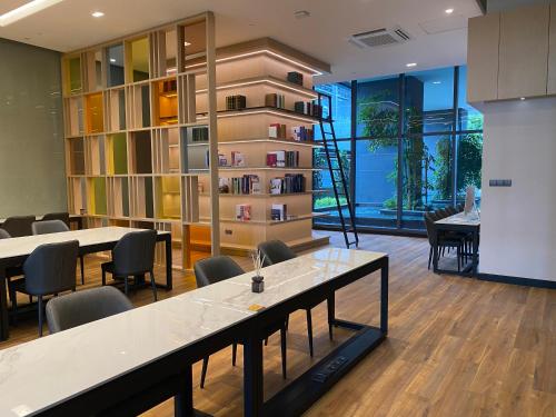 a room with tables and chairs and a book shelf at AXQUISITE SUITES at KLCC in Kuala Lumpur