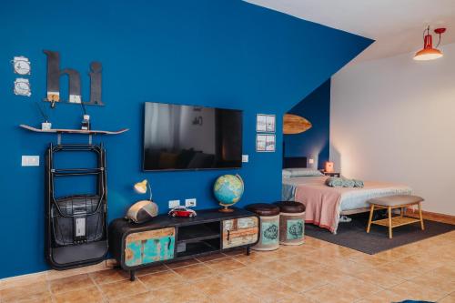 Habitación azul con cama y TV en Casa Allegranza, en Cotillo