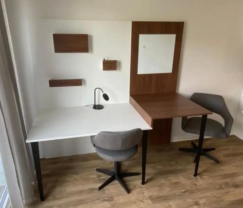 a white desk with a chair and a mirror at Gehobenes Apartment mit Balkon in Reutlingen