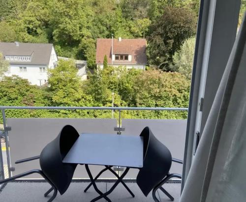 un tavolo bianco e 2 sedie sul balcone di Gehobenes Apartment mit Balkon a Reutlingen