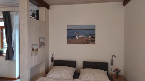 a bedroom with two beds and a picture of a bird at Hof Sturenberg in Quarnbek
