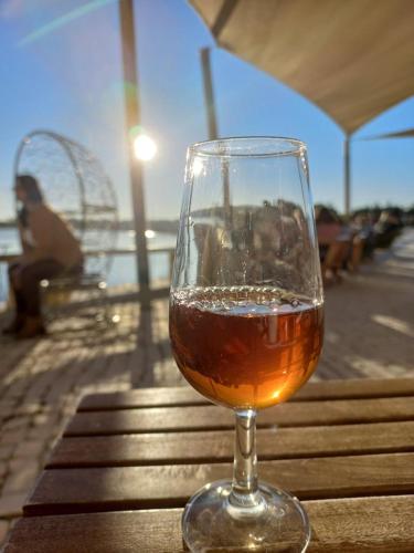 a glass of wine sitting on top of a table at A Casa do Chapéu de Palha in Setúbal