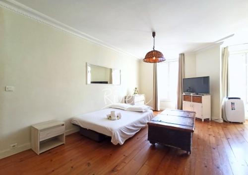 Un dormitorio blanco con una cama y un televisor. en Viva Riviera 5 Rue Florian, en Cannes