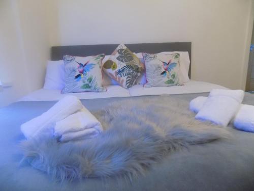 ein Bett mit einer pelzigen Decke und Kissen darauf in der Unterkunft Rhiwbina House in Cardiff