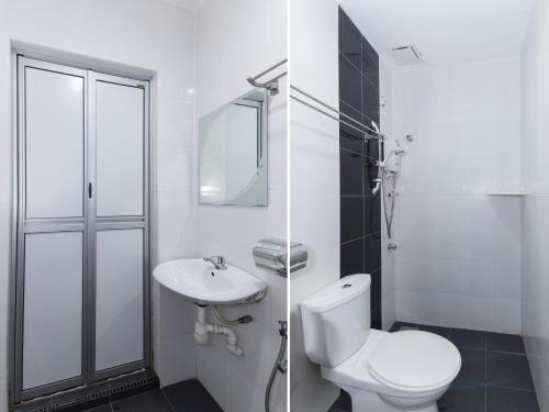 a white bathroom with a toilet and a sink at CHARISMA HOTEL in Kuantan