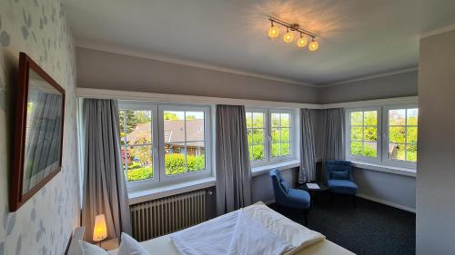 una habitación de hotel con cama y una habitación con ventanas en Hotel Schleimünde, en Kappeln