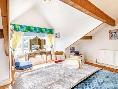 um quarto no sótão com uma cama e uma secretária em Central Tod Cottage em Todmorden