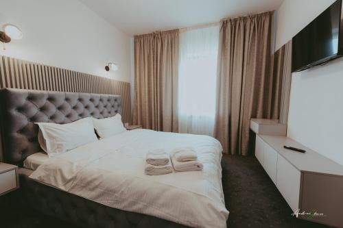 a hotel room with a bed with two towels on it at Pensiunea Belvedere in Ranca