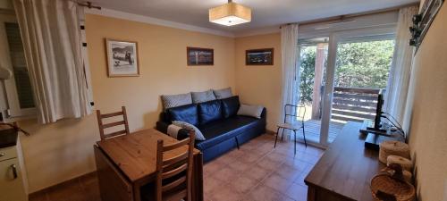 un salon avec un canapé bleu et une table dans l'établissement Apartament a Les Angles - Balcons du Pla del Mir, aux Angles
