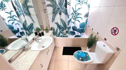 ein Bad mit einem WC und einem Waschbecken mit Pflanzen in der Unterkunft Melanos Sea View Apartment in Paphos City