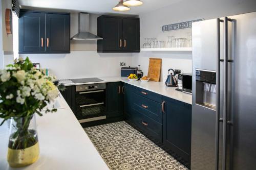 una cucina con armadi neri e frigorifero di Host & Stay - Saltburn Sea House a Saltburn-by-the-Sea