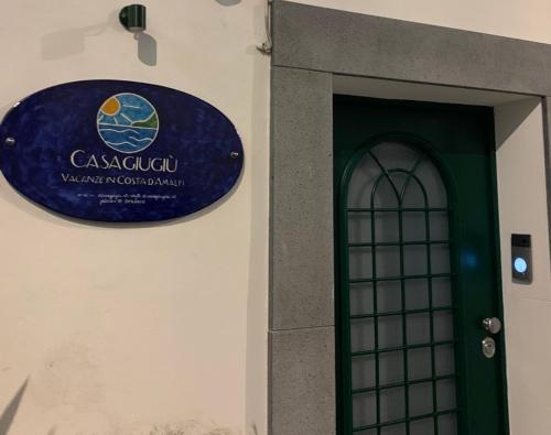 una señal en el lateral de un edificio con una puerta en Casagiugiù en Vietri