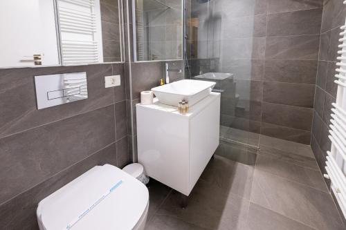 La salle de bains est pourvue de toilettes blanches et d'un lavabo. dans l'établissement Smart Concept Living Plaza, à Bucarest