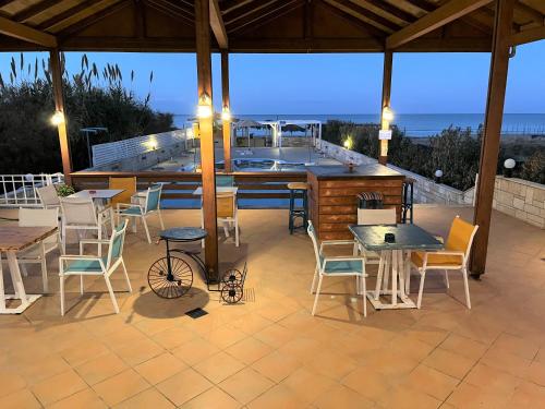 a patio with a bar and tables and chairs at Frank Apartments in Amoudara Herakliou